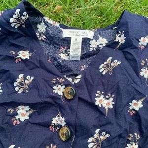 Navy blue blouse with flower prints and buttons.